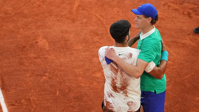 Carlos Alcaraz (back to camera) consoles Jannik Sinner after winning French Open
