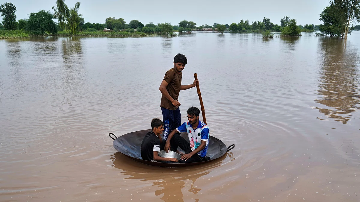 Villagers use a jaggery cooking pan as a makeshift raft to navigate floodwaters in Jhang district