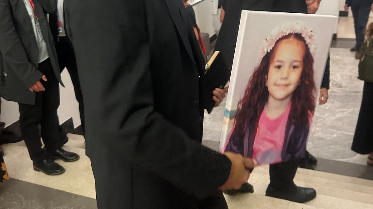 One of the film’s team carries a portrait of the slain child to the screening of The Voice of Hind Rajab 