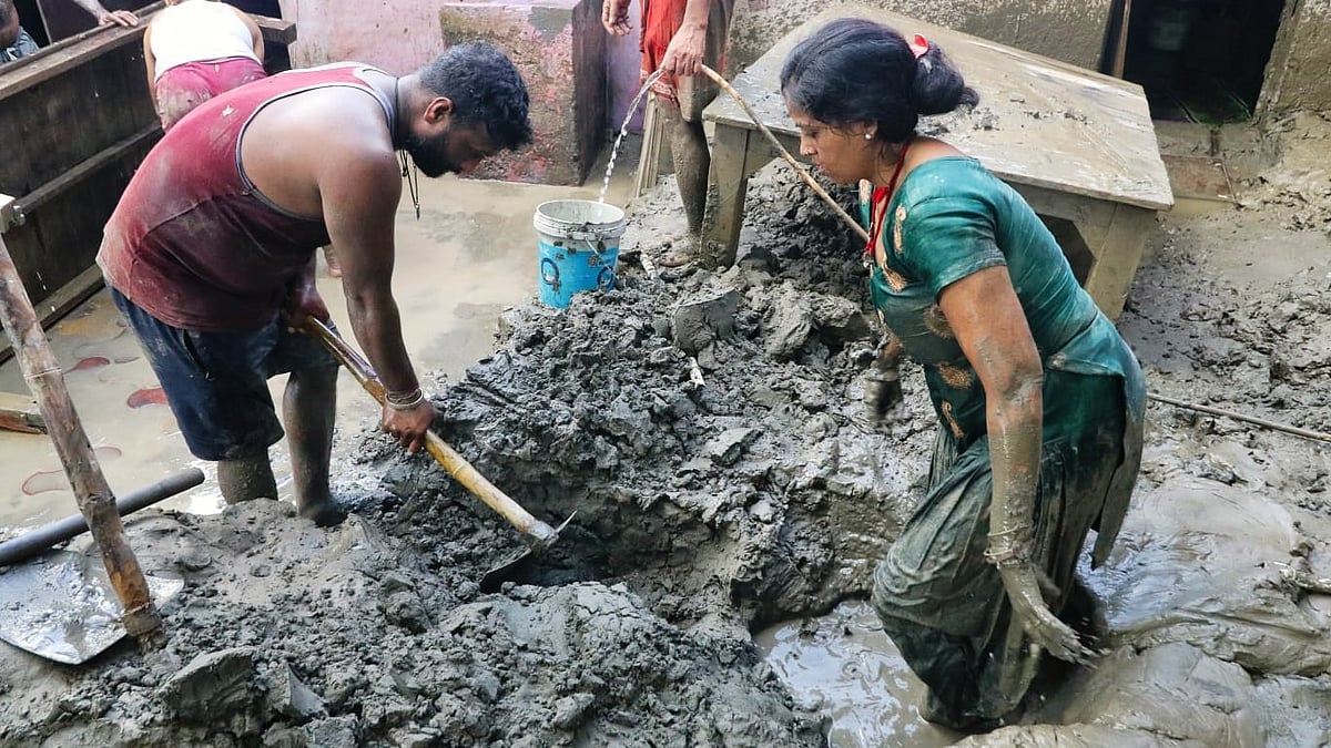 Residents of Yamuna Bazar clean slush from their houses after Yamuna waters receded in Delhi