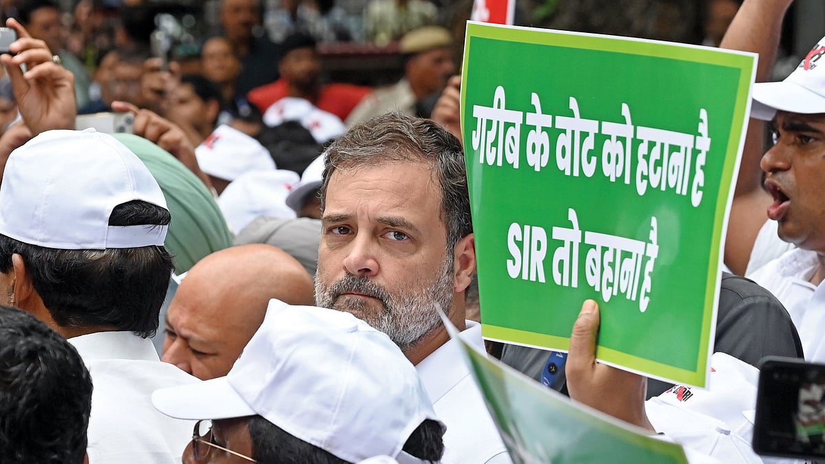 Near Gandhi is a banner that reads 'The SIR is just an excuse; the plan is to disenfranchise the poor' 