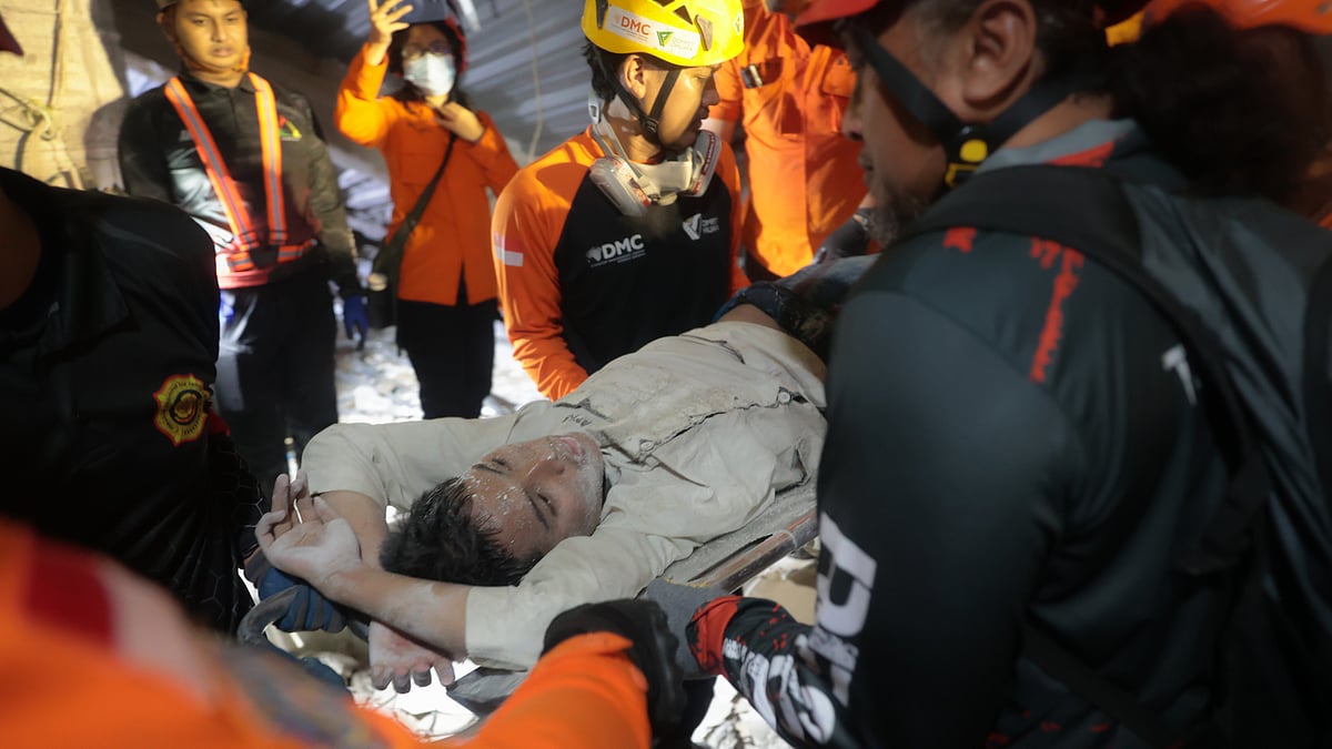 Rescuers run oxygen to Indonesia school collapse survivors, dozens still buried