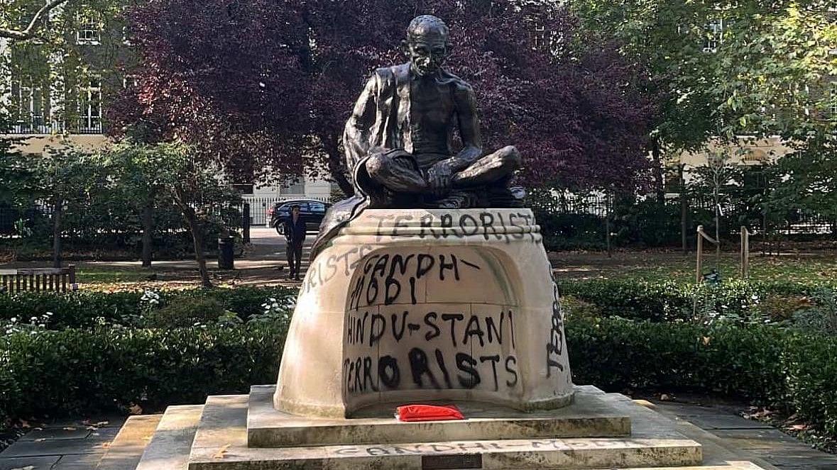 The Gandhi statue with graffiti sprayed at the plinth
