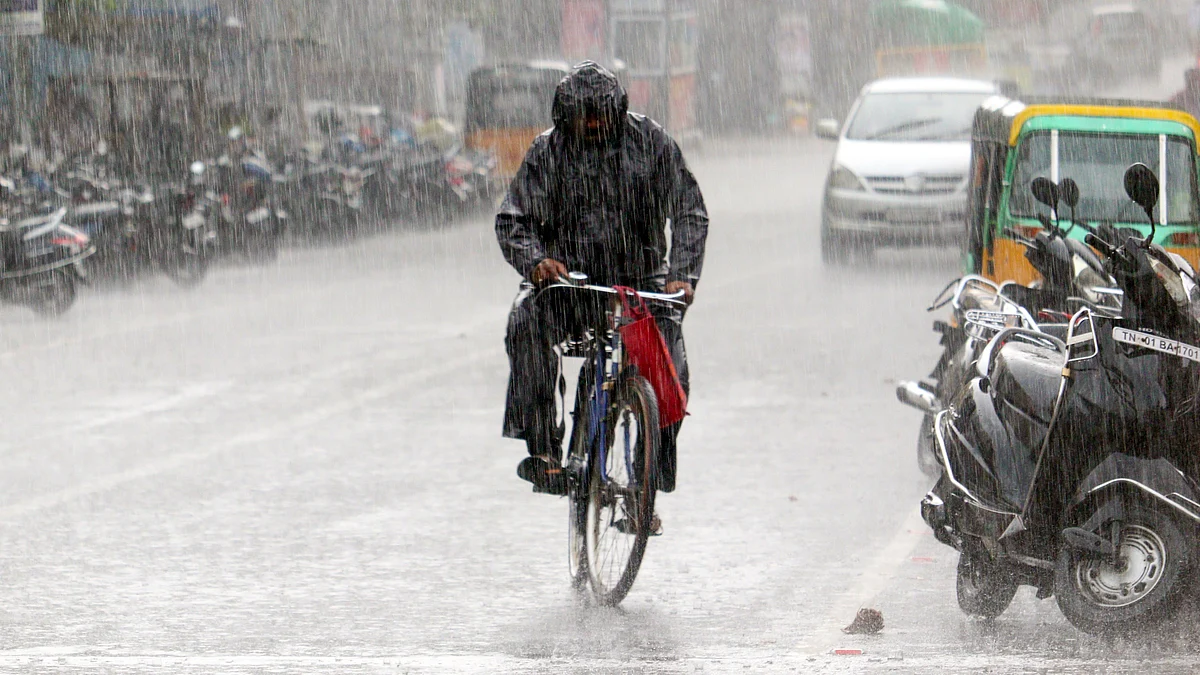 A cyclist pedals through rain-soaked streets in Chennai.