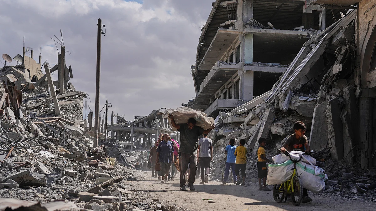 Displaced Palestinians walk through the ruins of Gaza.