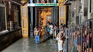 Devotees wait in a queue amid waterlogged Thiruchendur Murugan Temple in Thiruchendur.