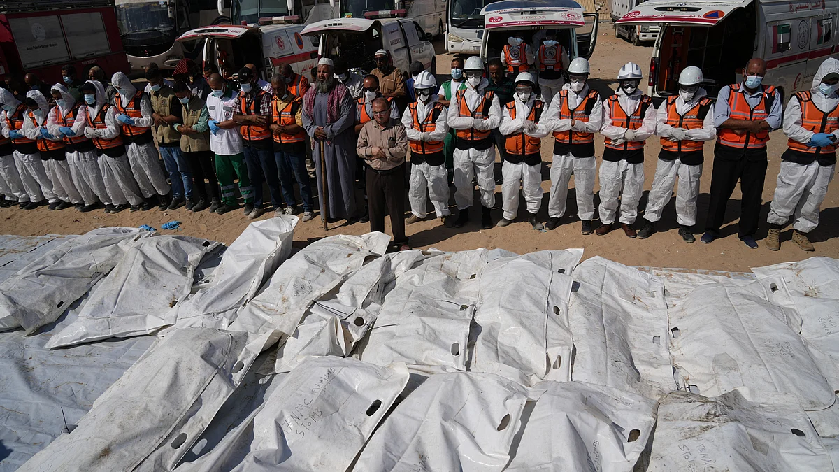 Medical workers pray over unidentified bodies returned by (Nasser Hospital, Gaza, 27 October 2025)
