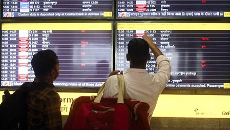 Passengers check flight information amid delays at Delhi airport.