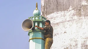 A cop removes a loudspeaker from a building during a drive against illegal loudspeakers in Lucknow.