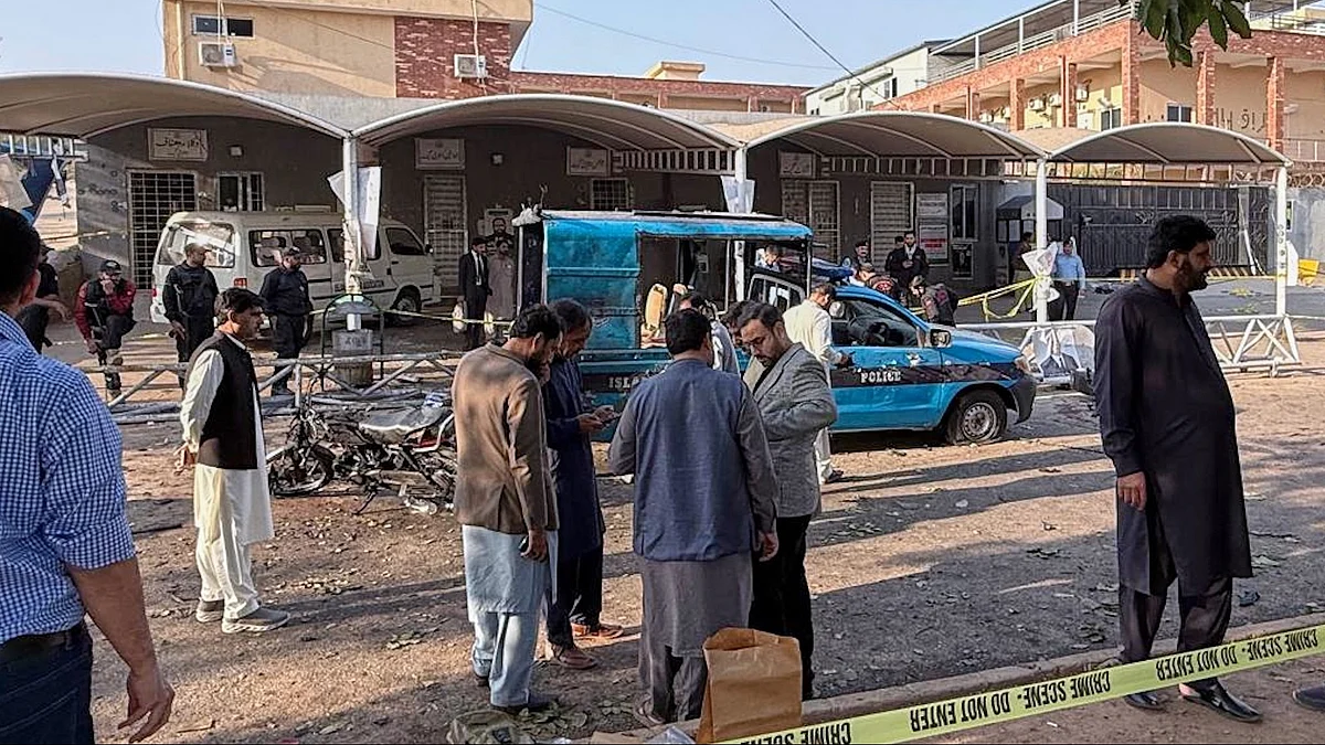 Security officials examine a vehicle at the site following a outside the gates of a court. 