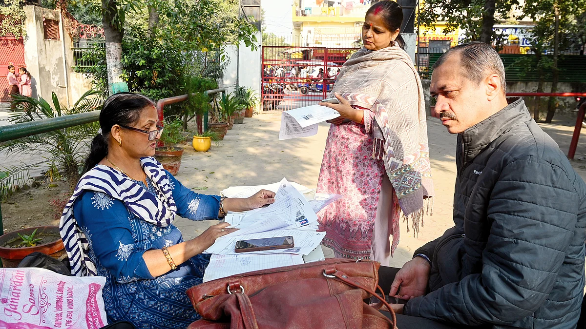 A BLO helps voters fill their enumeration forms in Noida, 1 December