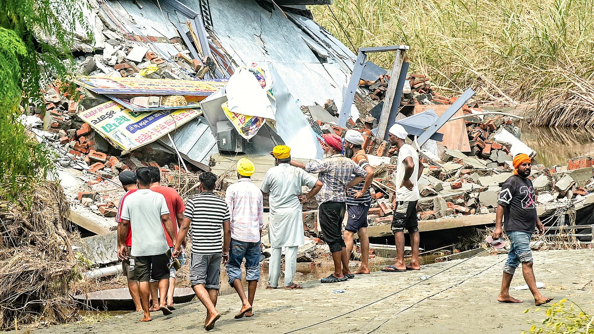 Villagers near Amritsar assess the damage to a house after the Punjab floods of early September