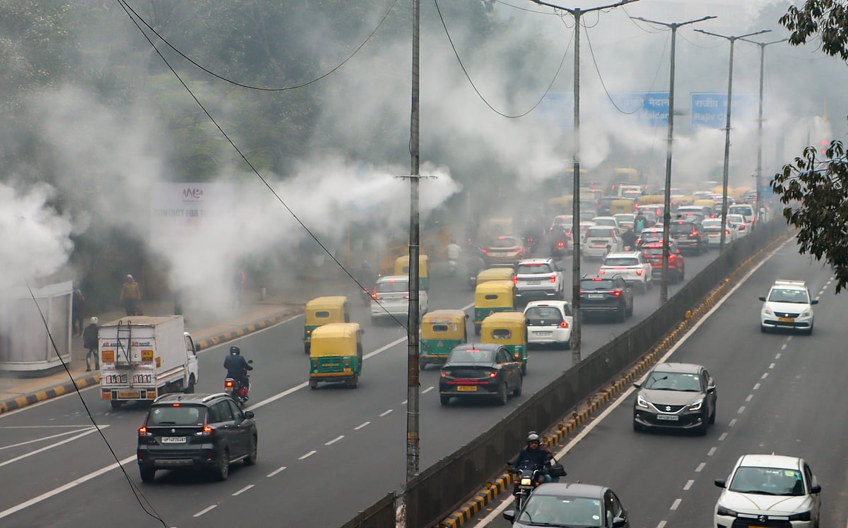 Water sprinklers operate under dense fog on a winter morning, in New Delhi.  