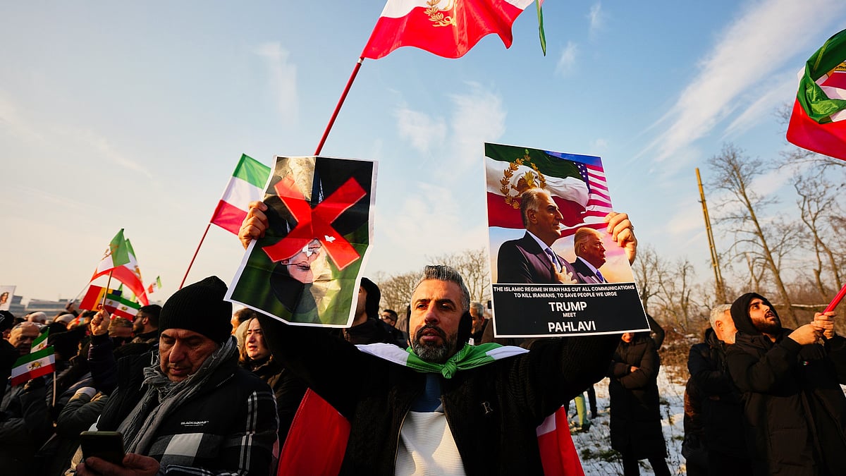 Iranians hold posters of their exiled crown prince and Trump at a rally in Romania