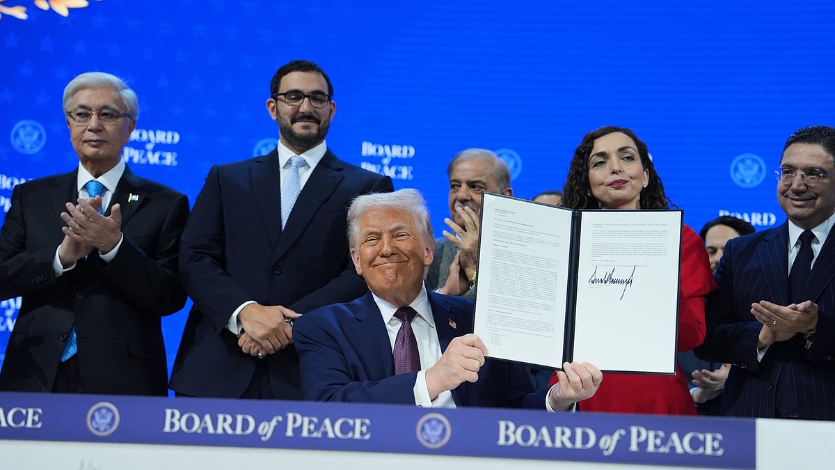 President Donald Trump holds up a signed Board of Peace charter in Davos