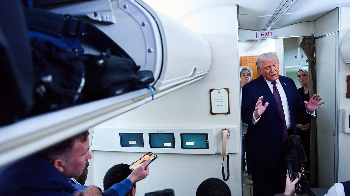 Donald Trump speaks to reporters aboard Air Force One as he leaves Davos for Washington, 22 Jan