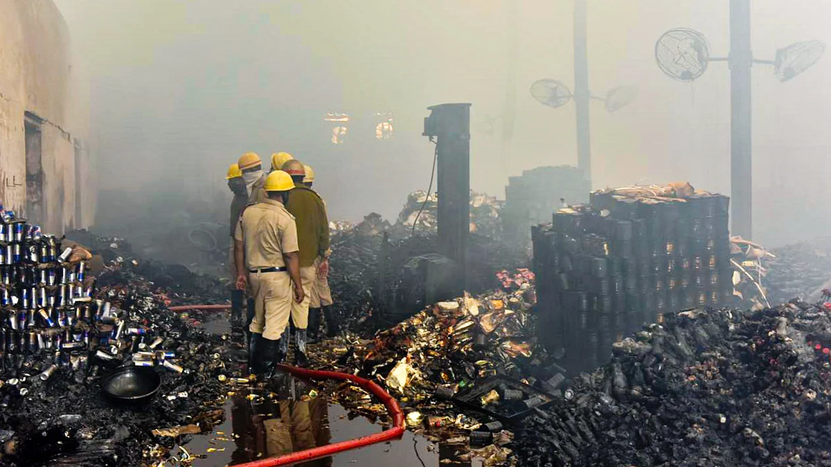Fire brigade personnel at the gutted warehouse in the Nazirabad area of Anandapur
