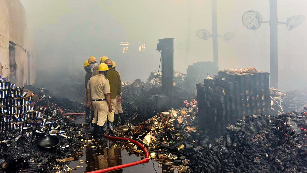 Fire brigade personnel at the gutted warehouse in the Nazirabad area of Anandapur