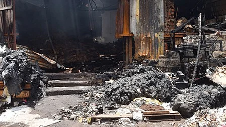 The charred Wow Momo factory premises after a deadly fire in Anandapur.