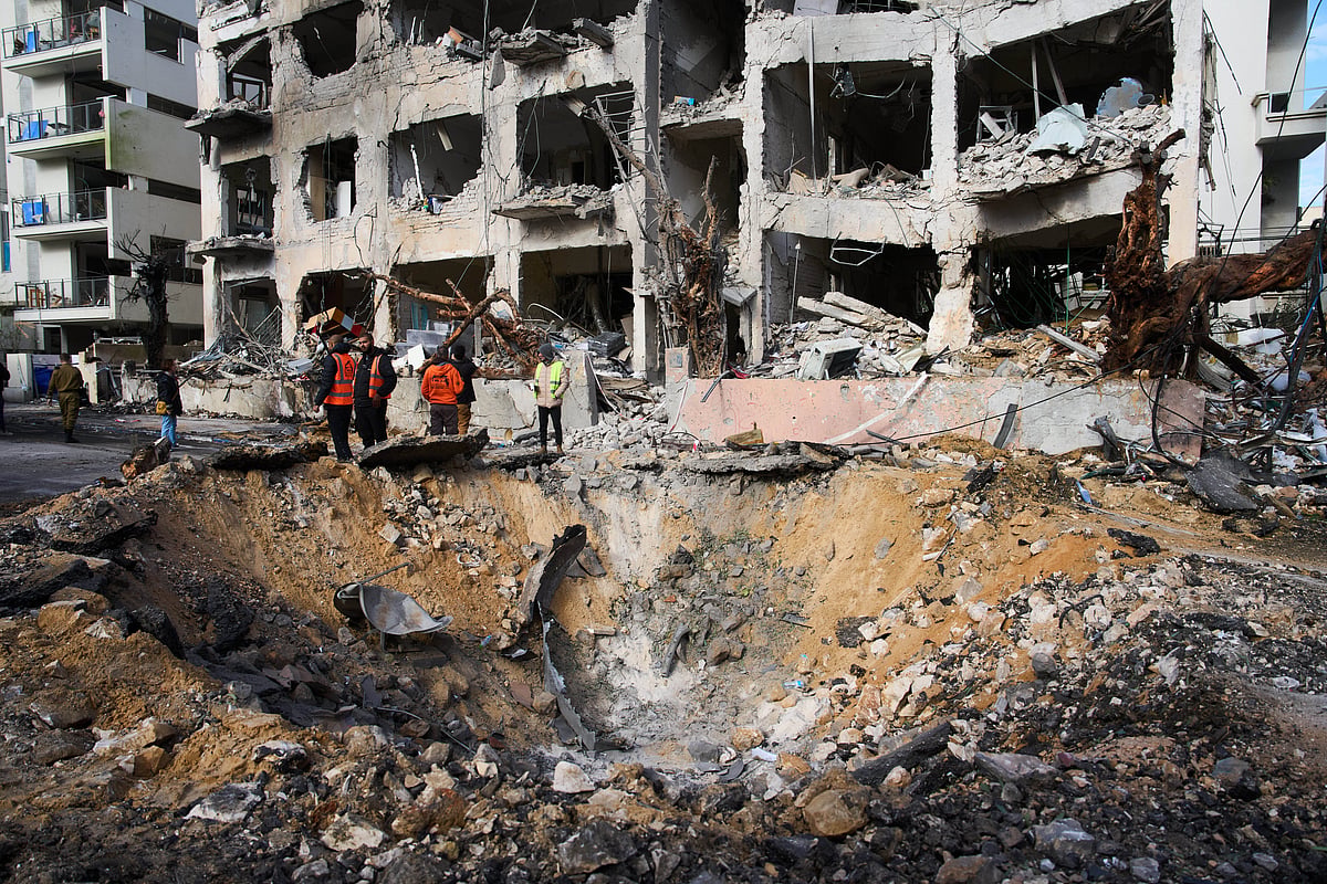 Rescue workers and military personnel survey the scene of a direct hit a day after an Iranian missile struck in Tel Aviv, Israel. 