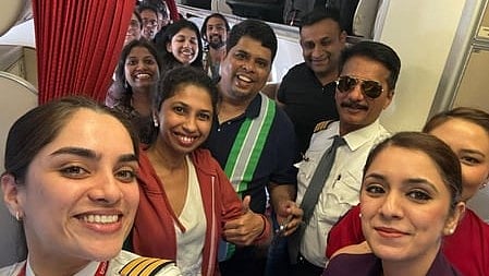 An Air India pilot captures a celebratory selfie with passengers after their safe return home.
