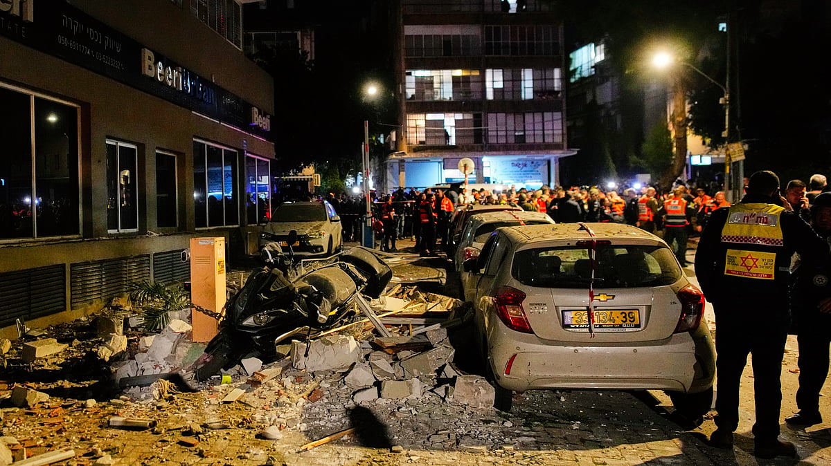 Israeli security forces inspect the site of a missile strike that killed two people in Ramat Gan, 18 Mar