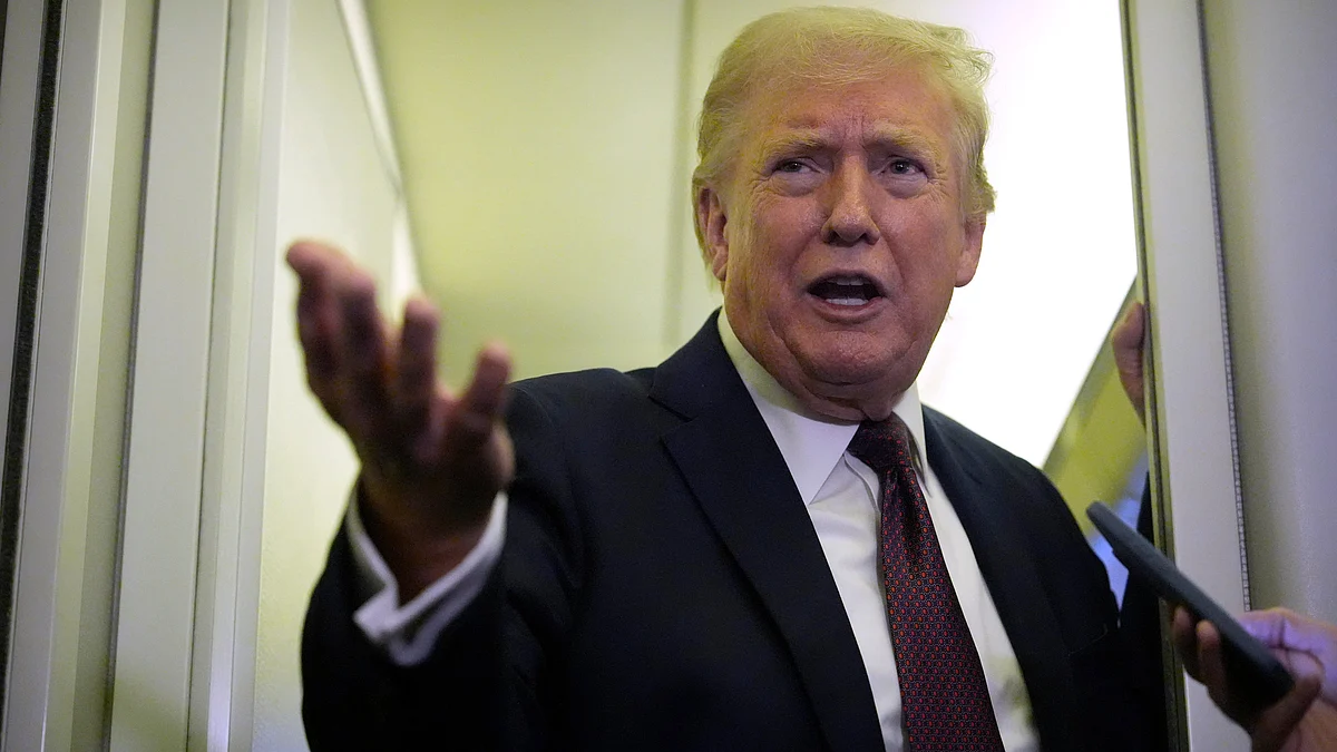 Donald Trump speaks to reporters aboard Air Force One.