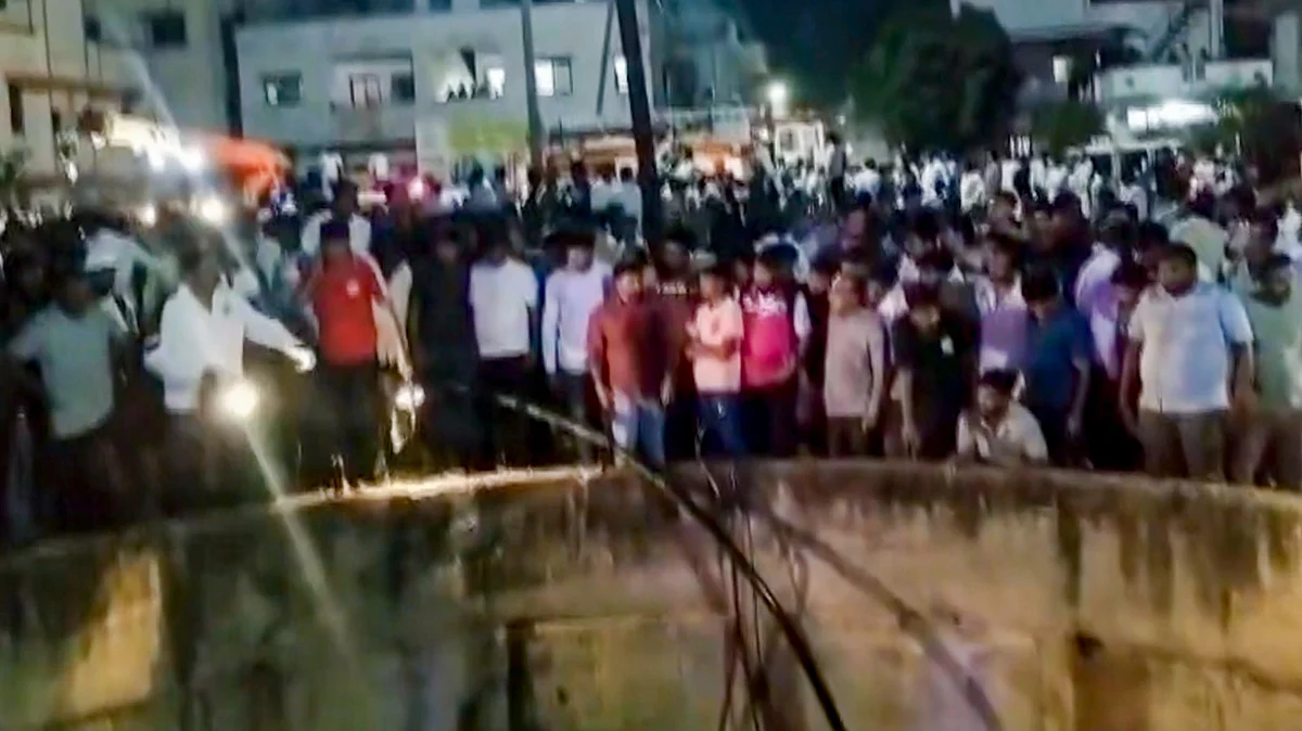 People gather around a well after a car fell into it killing nine people.