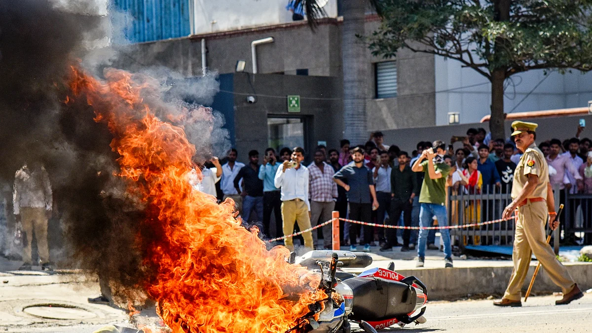 A police bike set ablaze by factory workers during the Noida protests, 13 April