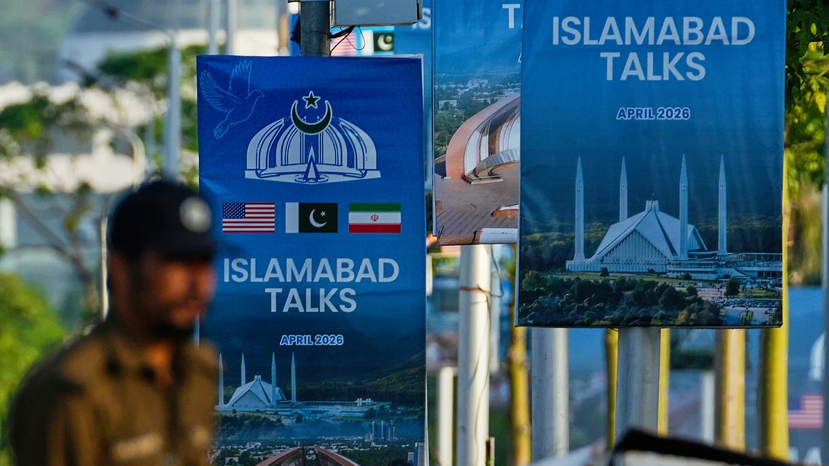 A police officer walks past posters of US-Iran talks near a possible venue in Islamabad, 25 April