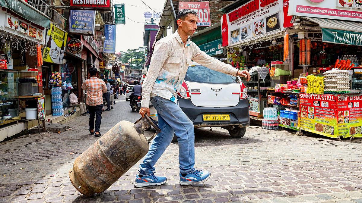 A man drags a refilled LPG cylinder in Dharamshala, Himachal Pradesh