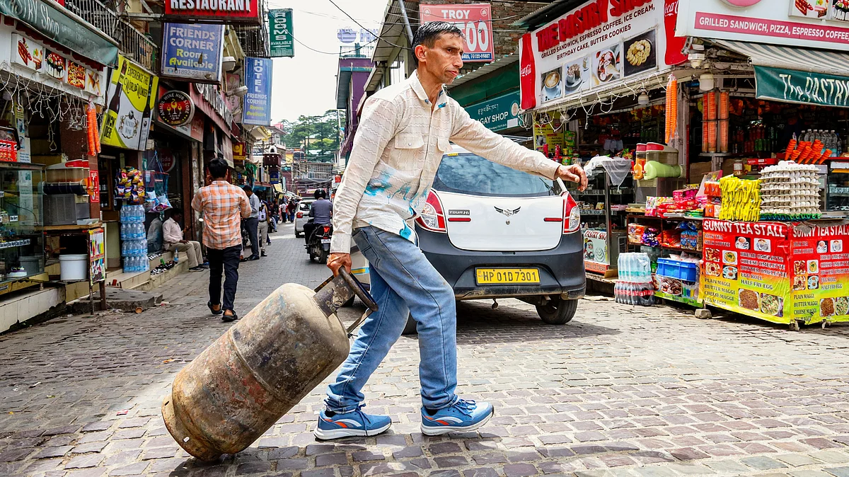 A man drags a refilled LPG cylinder in Dharamshala, Himachal Pradesh