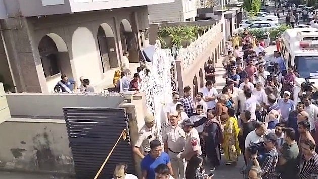 People gather outside the residence in Vivek Vihar.