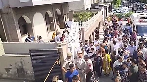 People gather outside the residence in Vivek Vihar.