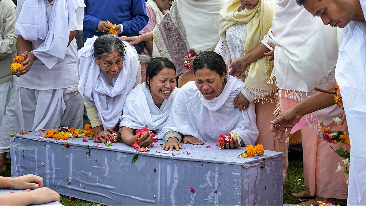 Bereaved family members perform the last rites of 2 children, who were killed in a bomb attack.