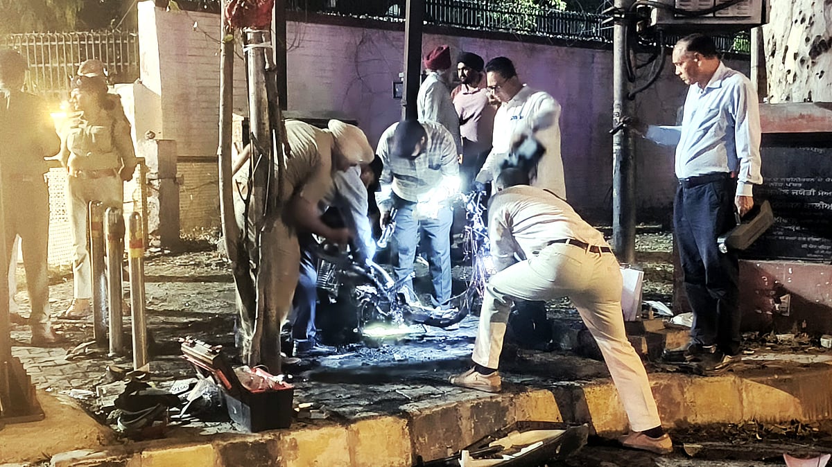 Security personnel inspect the remains of a scooter in Jalandhar.