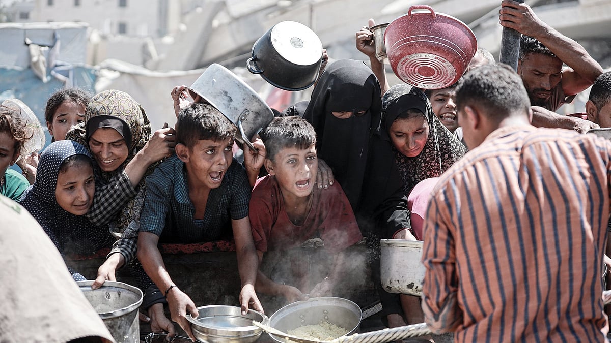 Starving Palestinians wait for food at an aid distribution point in Gaza