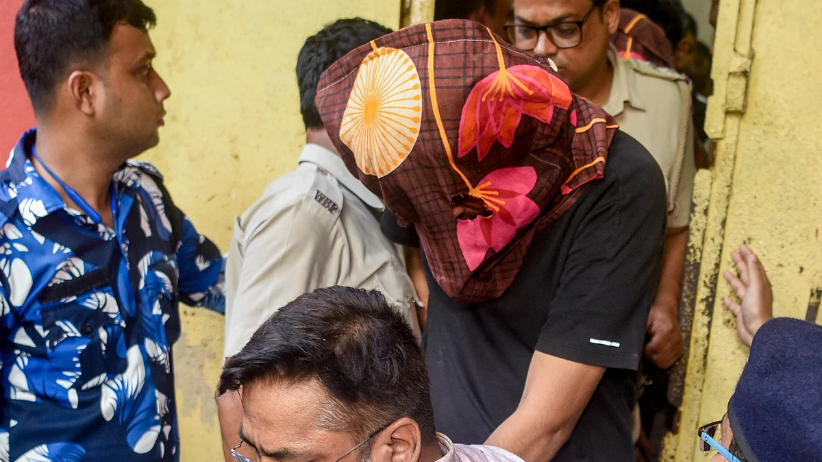 Police escort one of the suspects arrested in connection with the murder of Chandranath Rath, 11 May