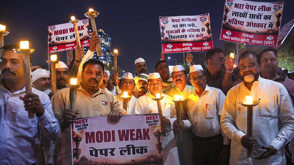 Congress workers take out a torch rally in protest against the cancellation of NEET-UG 2026.