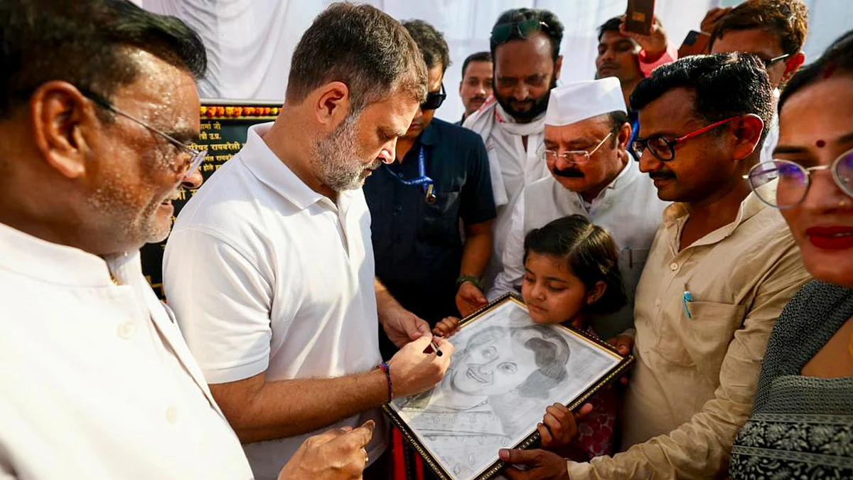 Rahul Gandhi signs a portrait of Indira Gandhi held by a girl during his visit to Raebareli
