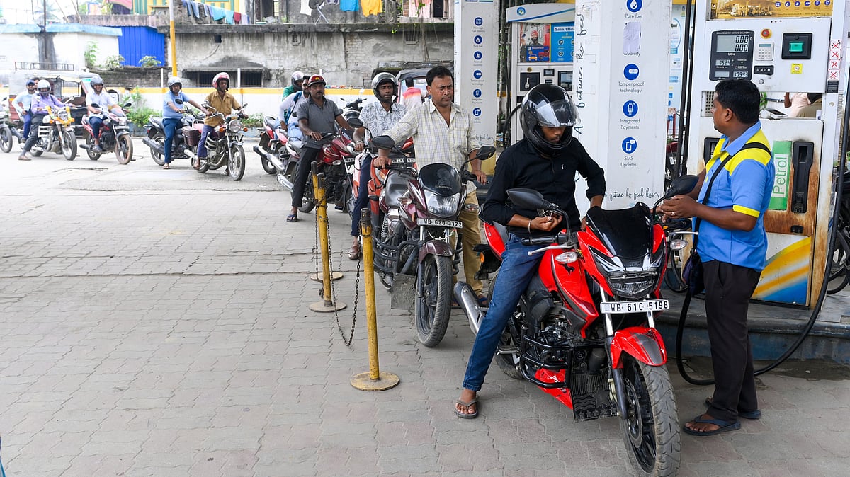 Commuters queue up at a petrol pump in Balurghat.