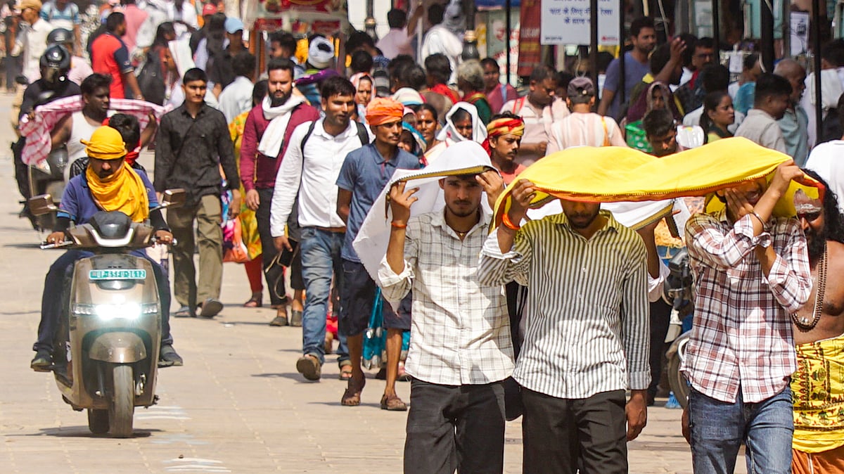 People walk amid severe heatwave conditions in Varanasi.