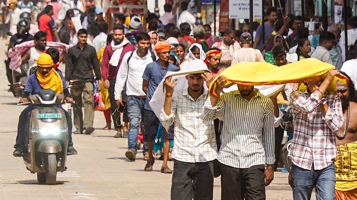 People walk amid severe heatwave conditions in Varanasi.