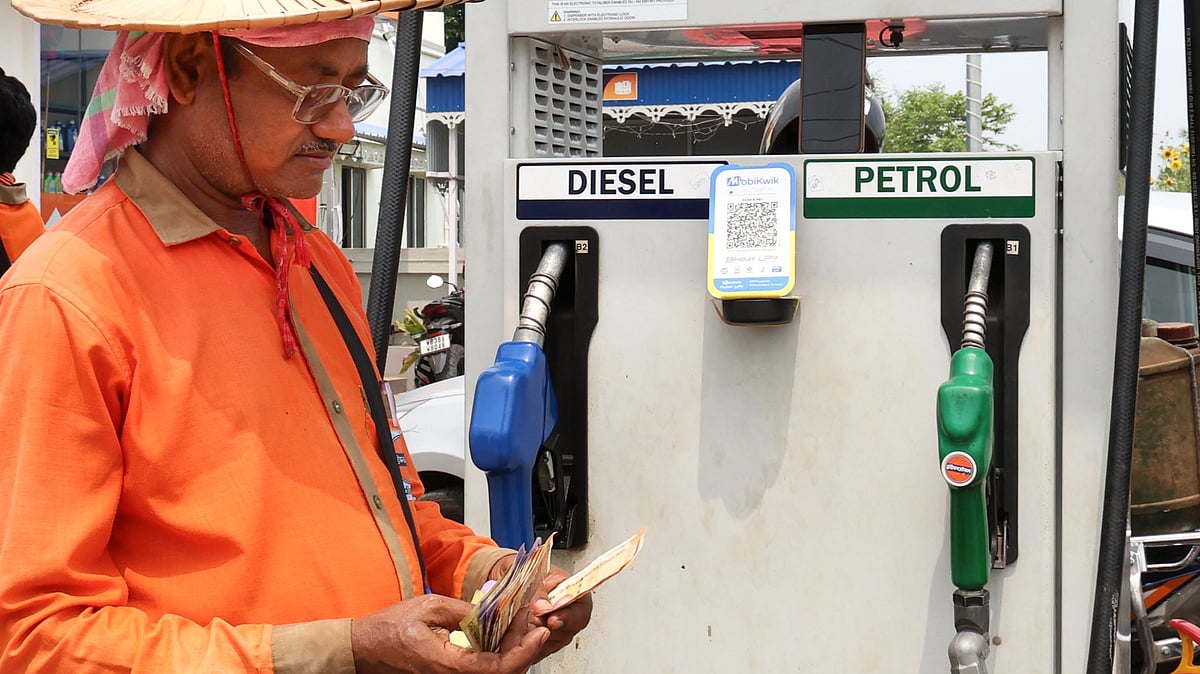 An employee counts money at a fuel station in Birbhum, West Bengal, 19 May
