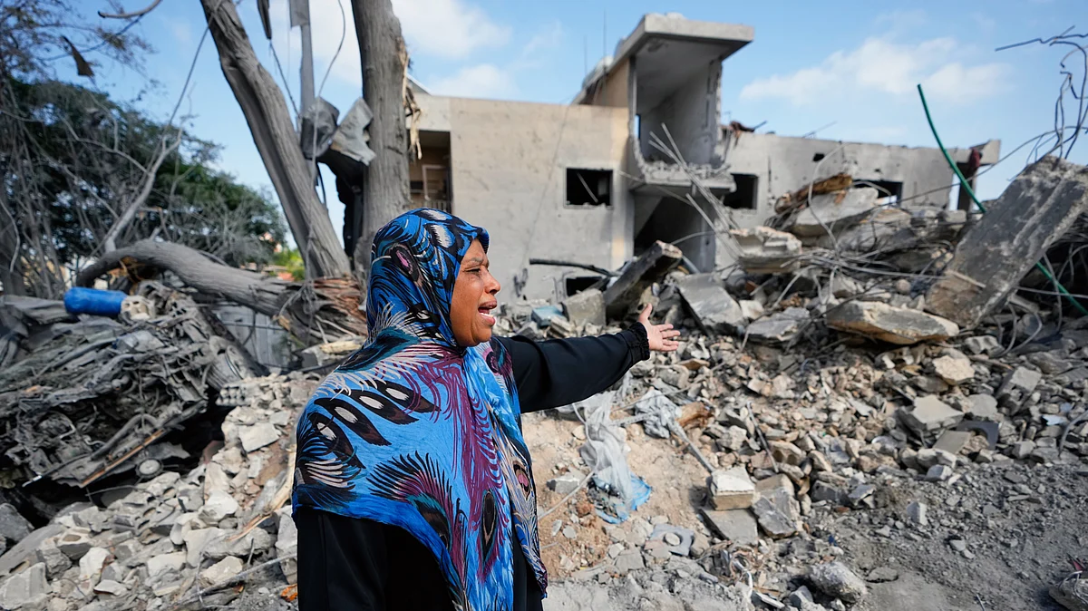 A woman near the rubble of her home destroyed in an Israeli airstrike in the village of Maarakeh, 27 May