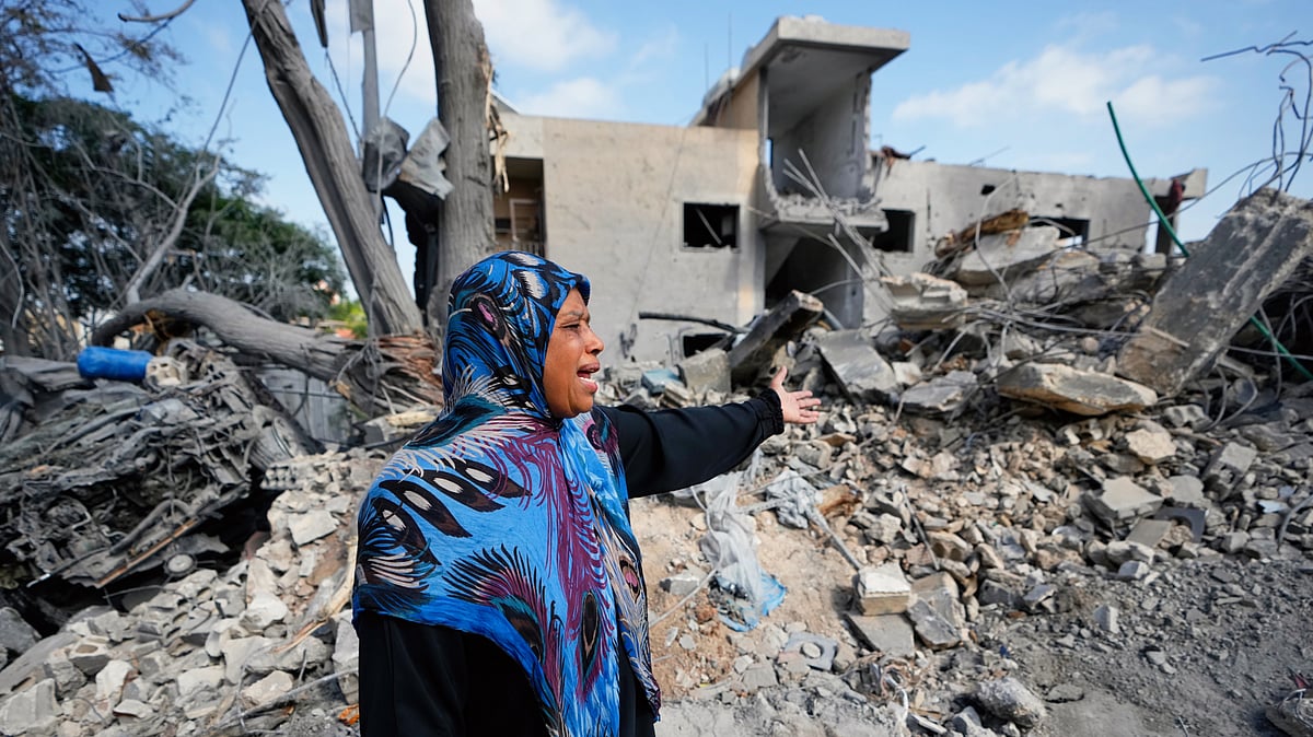 A woman near the rubble of her home destroyed in an Israeli airstrike in the village of Maarakeh, 27 May