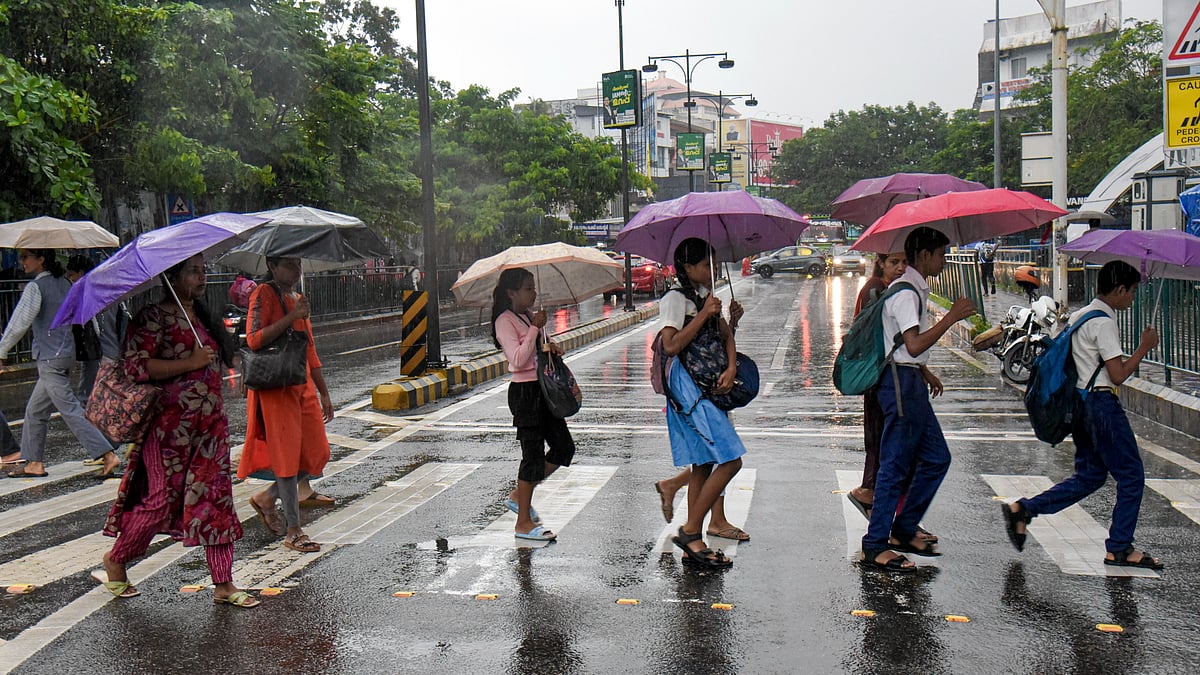 People shield themselves from rain in Kochi.