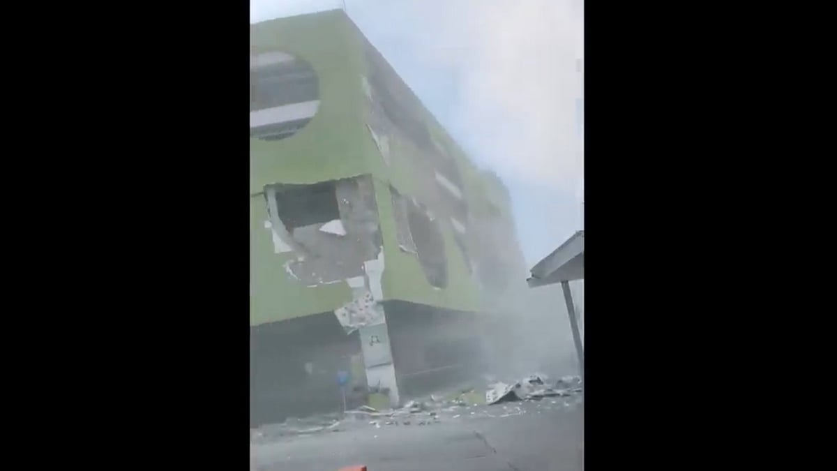 Video grab shows dust and debris outside a building in Philippines.