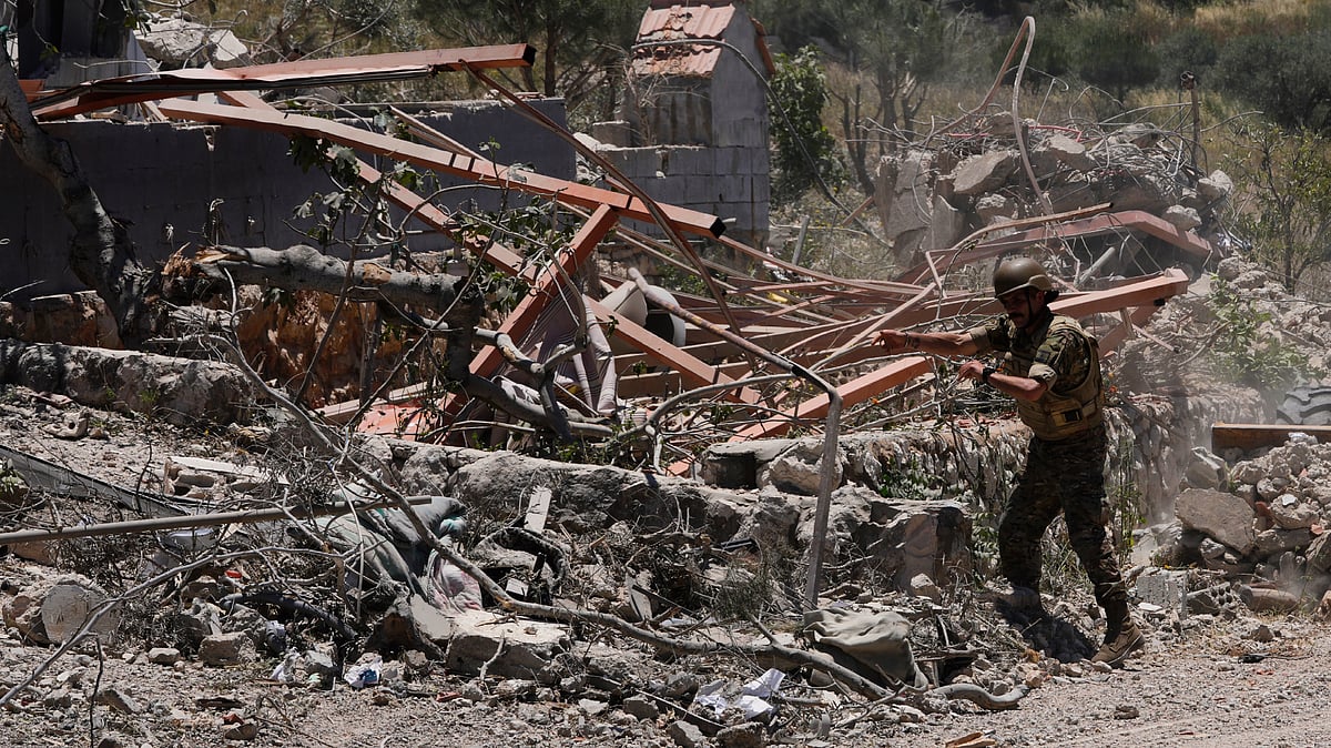 A Lebanese soldier removes rubble from clashes between Hezbollah and Israeli fighters