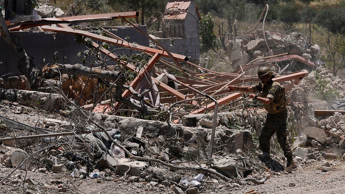 A Lebanese soldier removes rubble from clashes between Hezbollah and Israeli fighters
